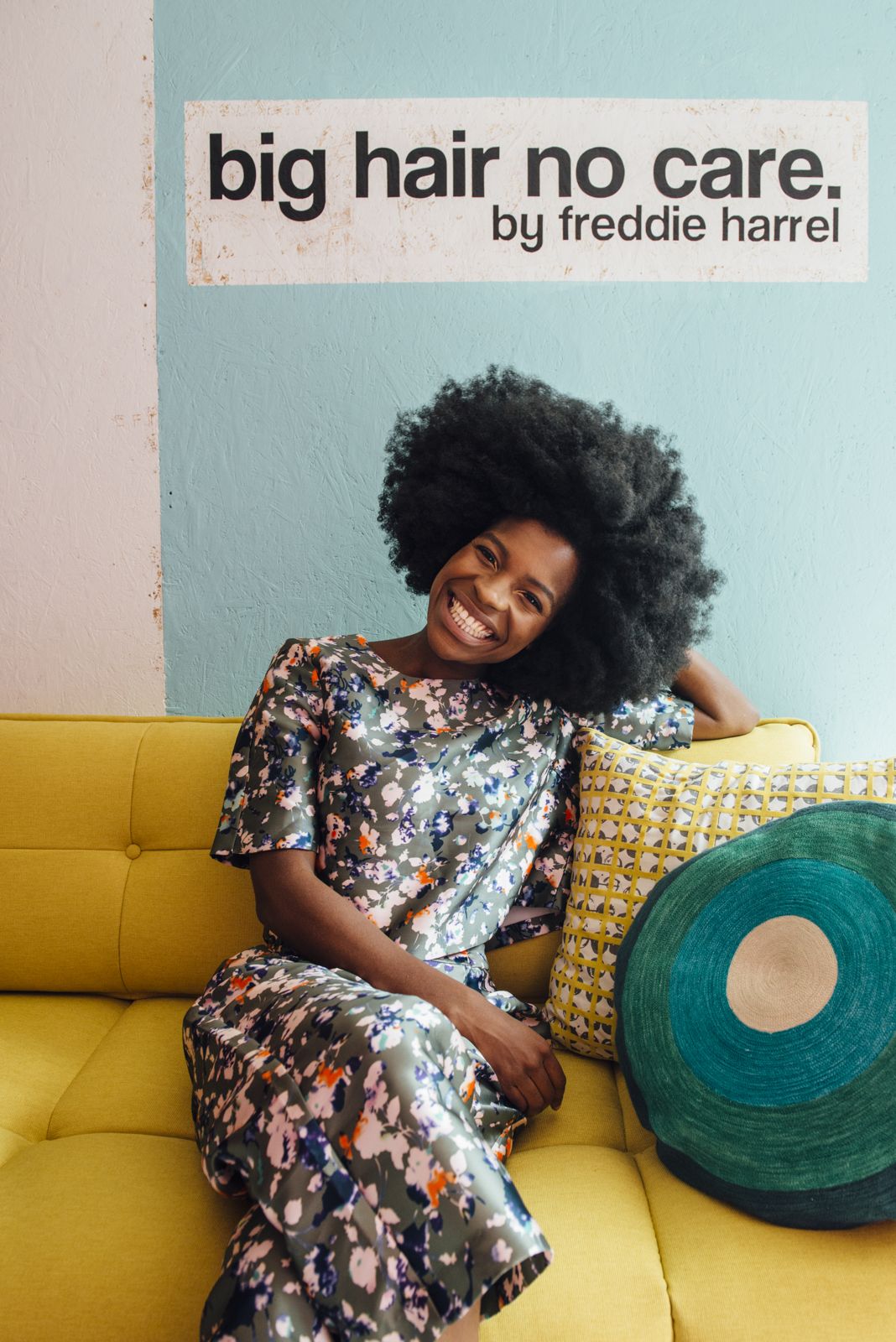 Freddie on a yellow sofa under the Big Hair No Care sign